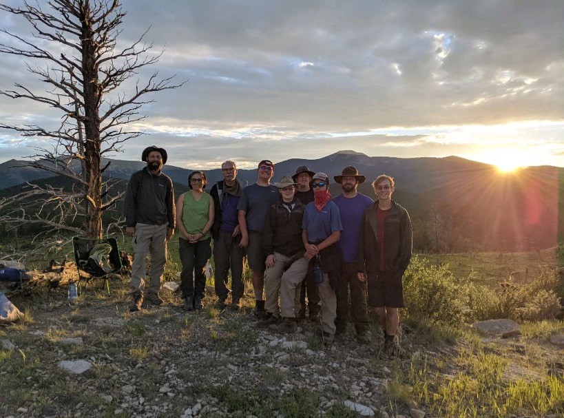 Boy Scouts Troop 152 at Philmont Scout Ranch in New Mexico standing with mountain landscape at sunset