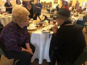 ladies in hats and gloves at Centennial Tea