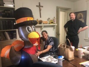 Fr. Kurtis Wiedenfeld and volunteer with giant inflatable turkey at the 2021 Turkey Fundraiser