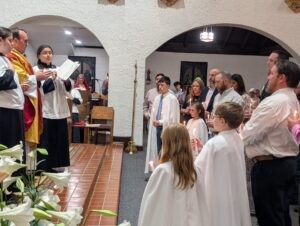 congregation gathered around father at mass